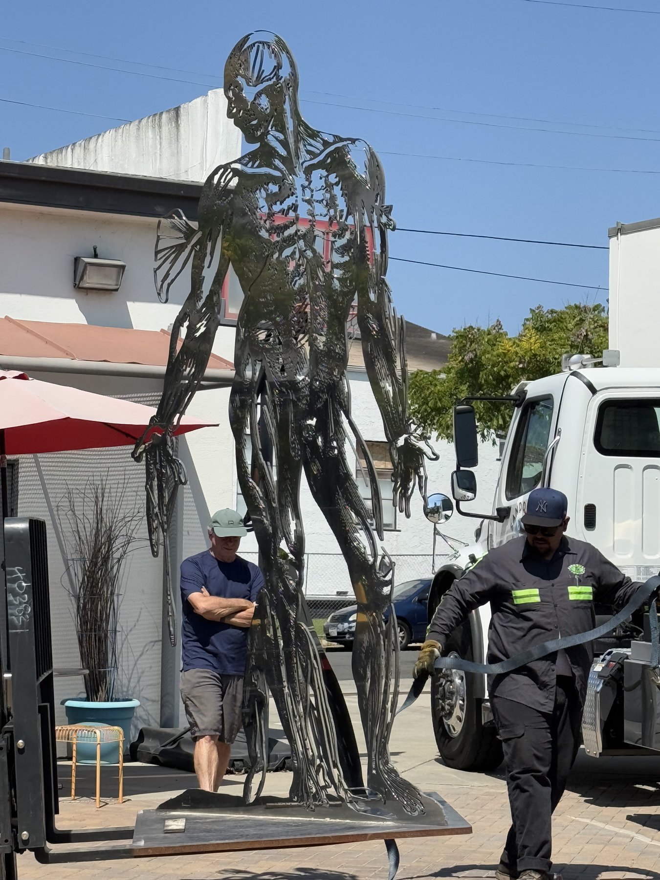 Cor Fabrica being received on site, standing upright with installation crew at work, July 24, 2025