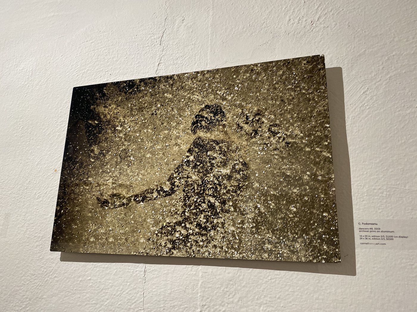 dancers, installation view at Cornel/Henry Art, San Diego, 2019 — a framed photograph of a single figure in sparse gold spray, on a white wall