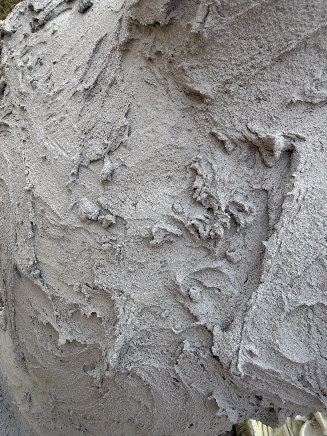 lorem ipsum, surface detail — torn-edged terraced cement layers, the trowel-marked material caught mid-spread
