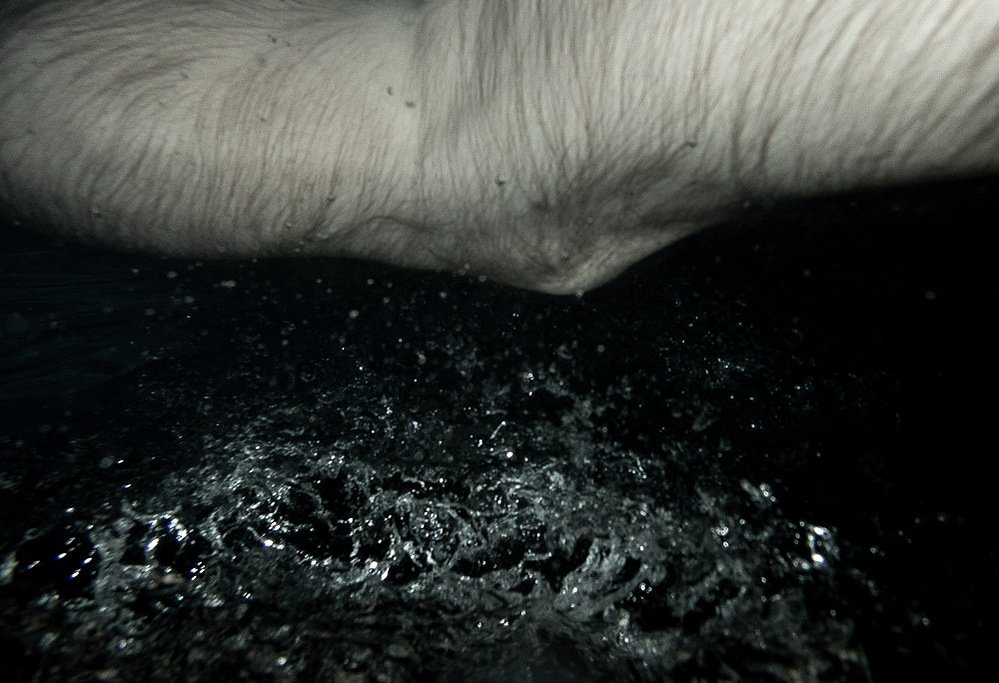night swim #4, arm at the water surface with bubbles below, 2020