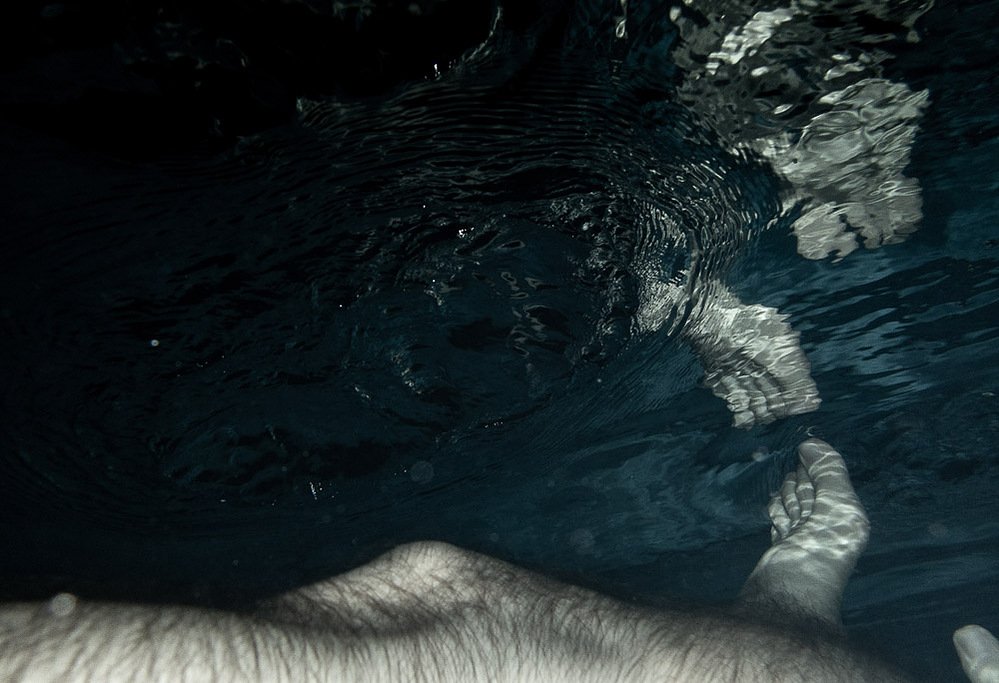 night swim #5, feet emerging at the water surface seen from below, 2020