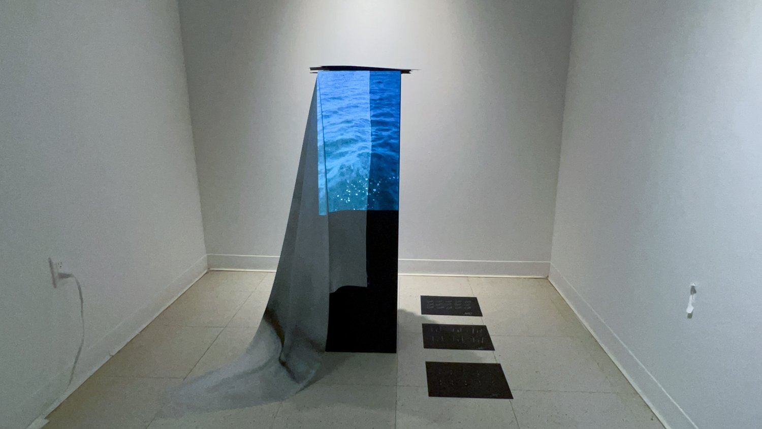 the take away — pedestal with blue water-projection silk drape and paper cards on floor, Fine Arts Studios, School of Visual Arts, New York, 2022