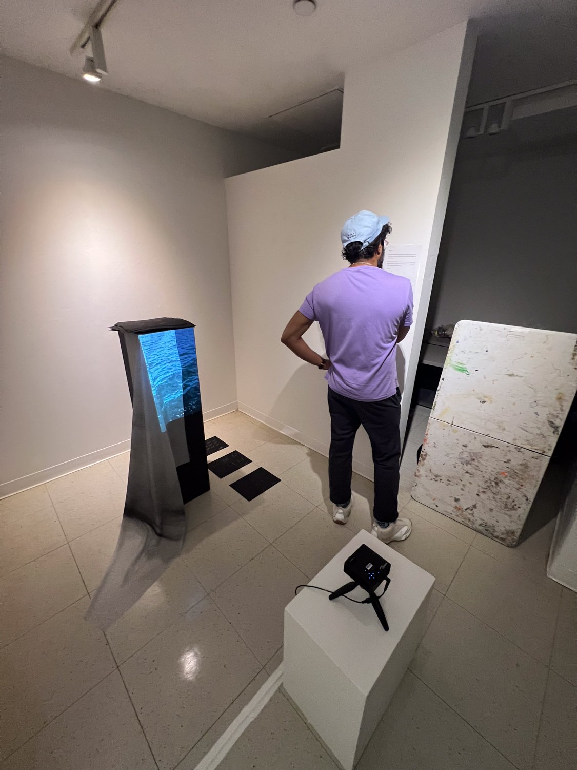 visitor viewing the take away from the side, with the projector visible on its tripod, Fine Arts Studios, School of Visual Arts, New York, 2022